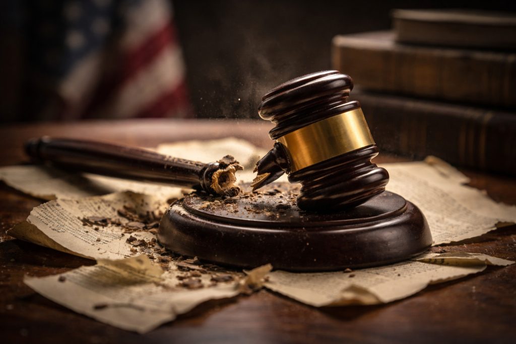 A broken judge's gavel on top of old papers, representing the fight to overturn common-sense-defying laws.